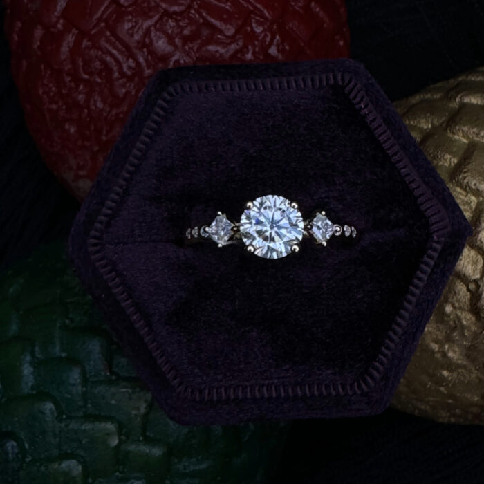 Gold moissanite in a ring box surrounded by dragon eggs